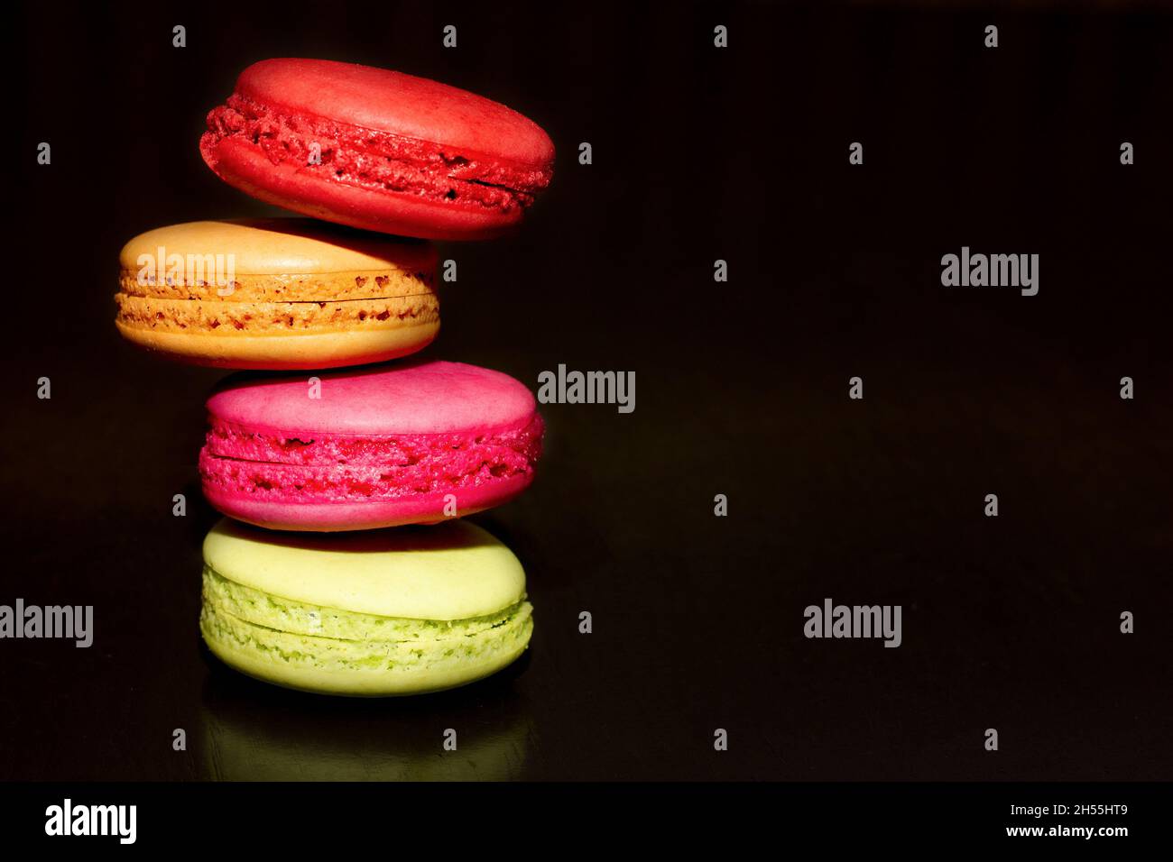 produits de boulangerie aux amandes colorées sur fond sombre, photo pour n'importe quel usage.Place pour votre texte. Concept d'usine culinaire et de confiserie. Macaroon Banque D'Images