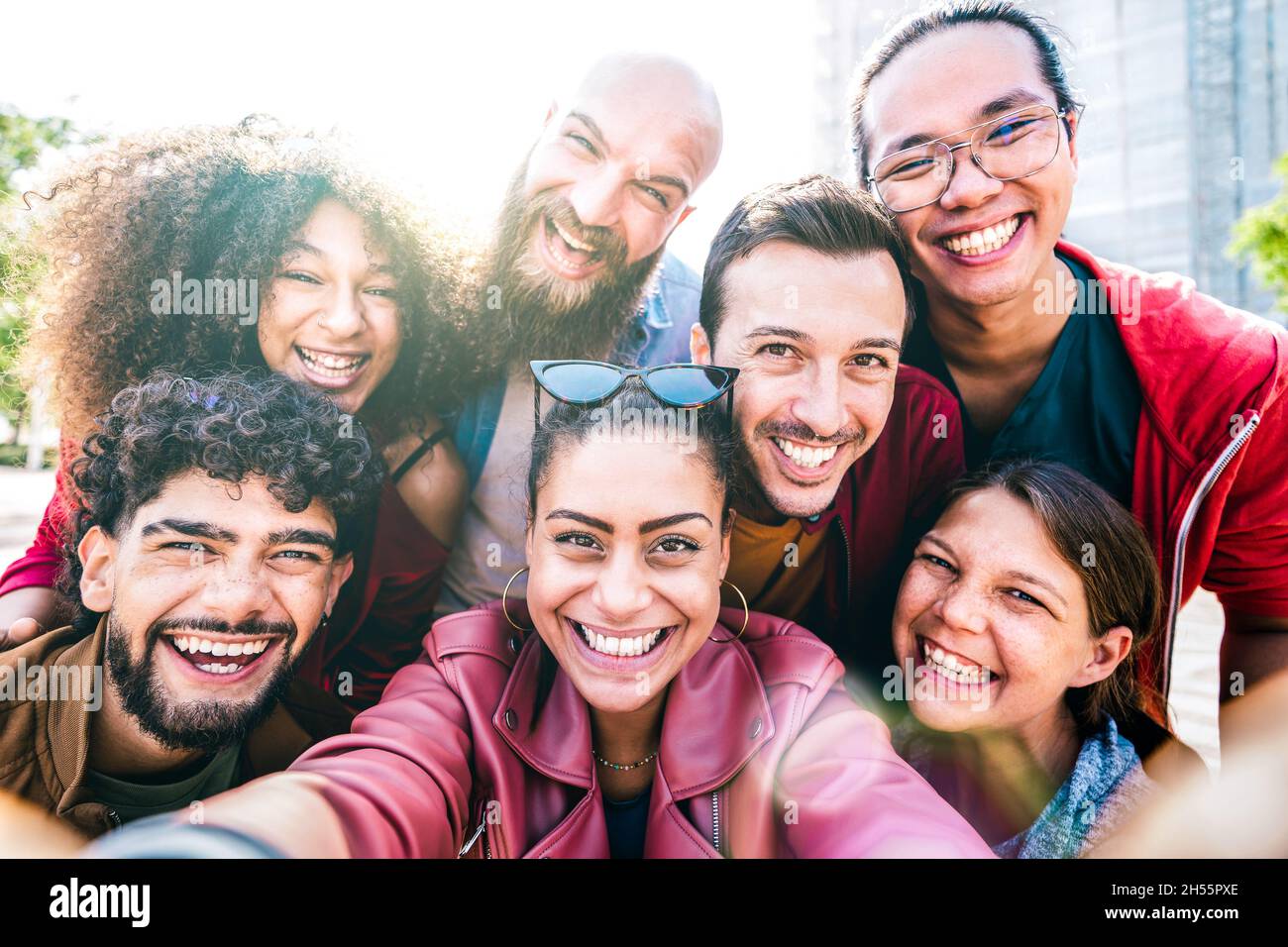 Multi-culturels les gars et les filles prenant le selfie à l'extérieur avec le contre-jour - heureux concept d'amitié milenial sur les jeunes amis multiraciaux ayant la journée de plaisir Banque D'Images