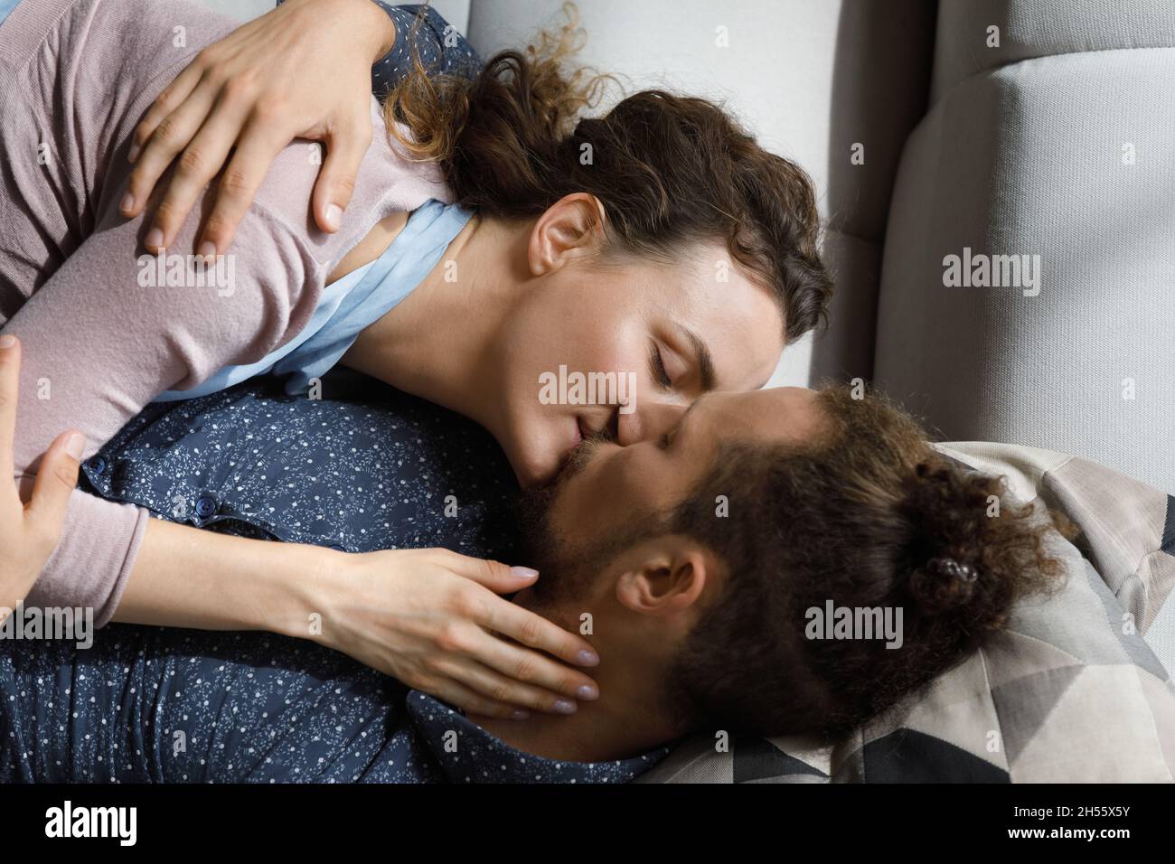 Un couple affectueux s'embrasse, se repose sur un canapé. Banque D'Images