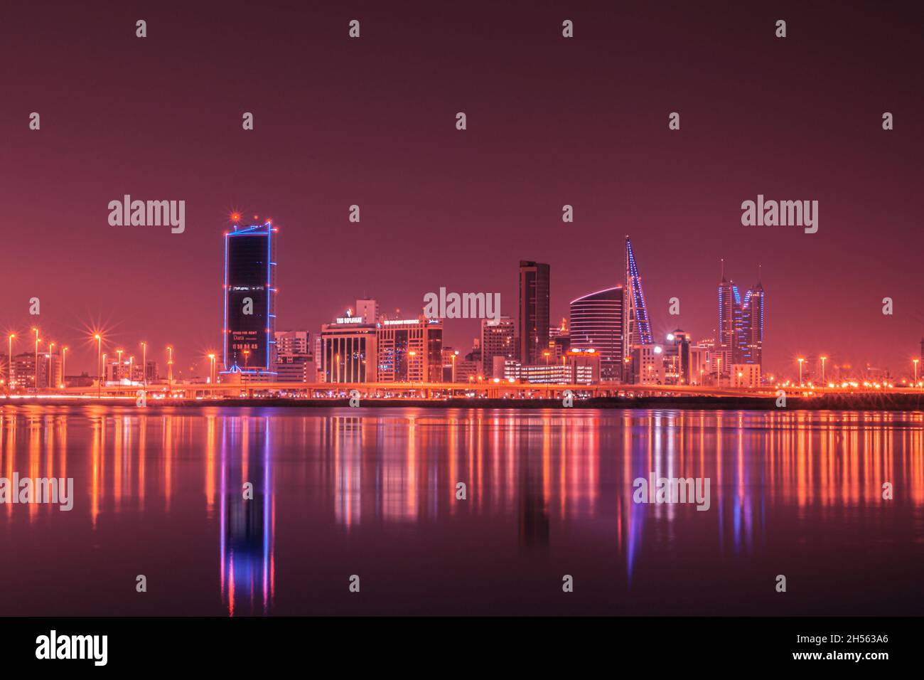 Horizon nocturne moderne avec lumières fluo et reflets dans l'eau.Manama, la capitale du Bahreïn, Moyen-Orient Banque D'Images