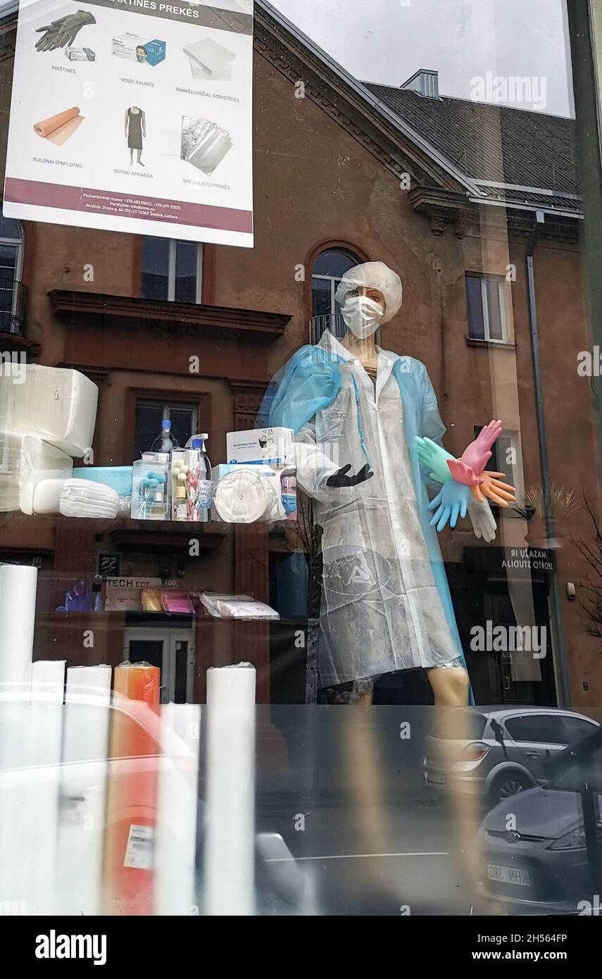 (211107) -- SIAULIAI, 7 novembre 2021 (Xinhua) -- Un modèle portant des robes et des gants médicaux est exposé dans une vitrine à Siauliai, Lituanie, 6 novembre 2021.Le gouvernement lituanien a accepté d'offrir un paiement unique de 100 euros (116 dollars américains) aux personnes âgées de 75 ans et plus qui se font vacciner contre le COVID-19 d'ici le 1er décembre et à celles qui prennent leur dose de rappel d'ici le 1er avril 2022.(Xinhua/Xue Dongmei) Banque D'Images