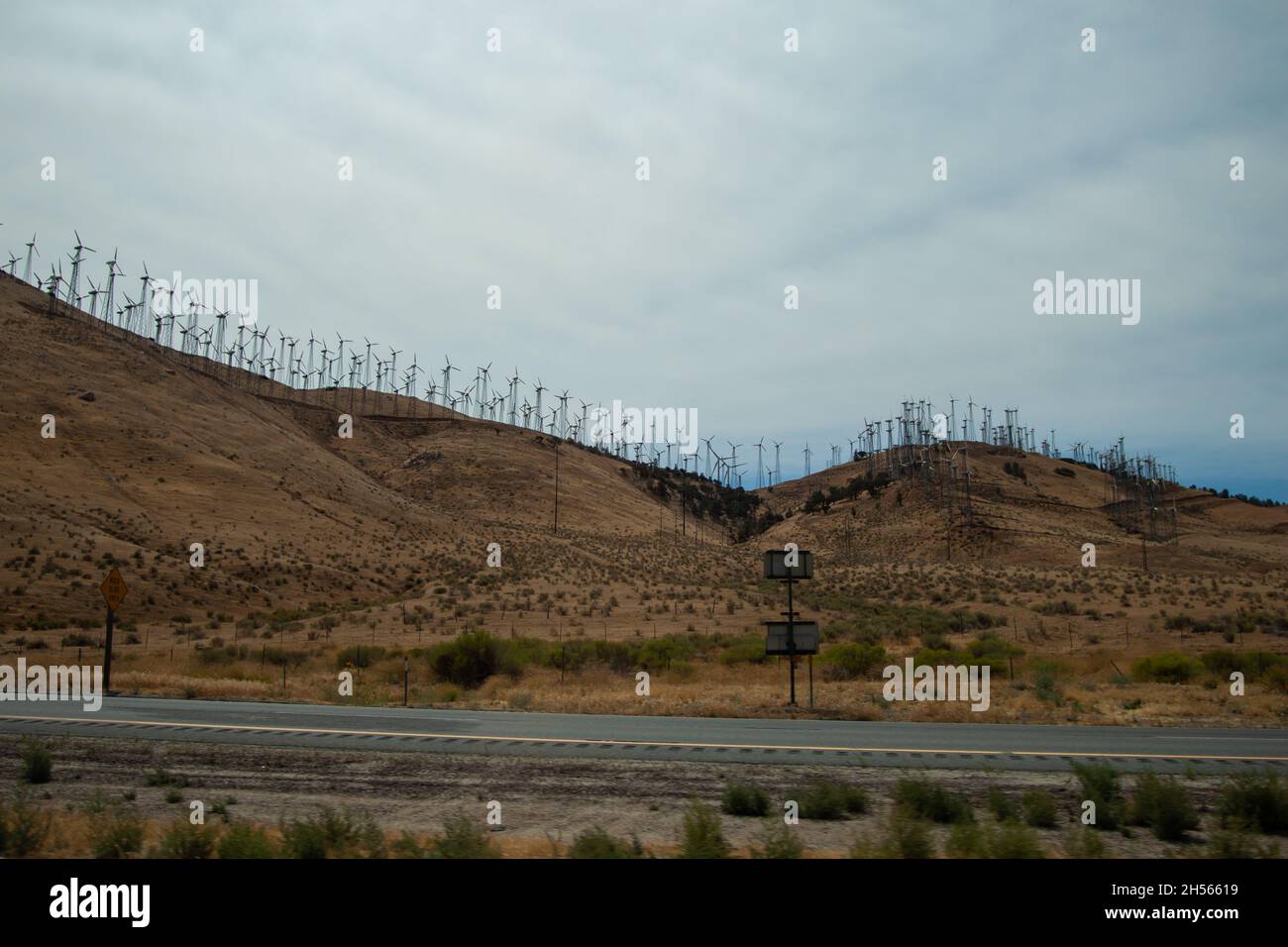 Paysage avec centrales éoliennes en rangées sur une colline | photo d'un parc éolien provenant d'une voiture de conduite, vues sur la route Banque D'Images