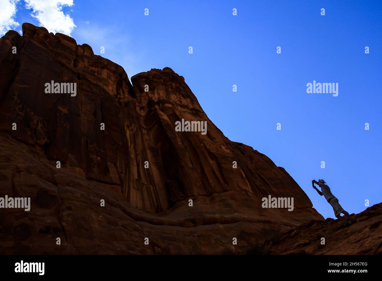 Homme prenant des photos des tours du palais de justice, le populaire parc national d'Arches présente une photo spectaculaire d'en dessous contre le soleil vue magnifique paysage Banque D'Images