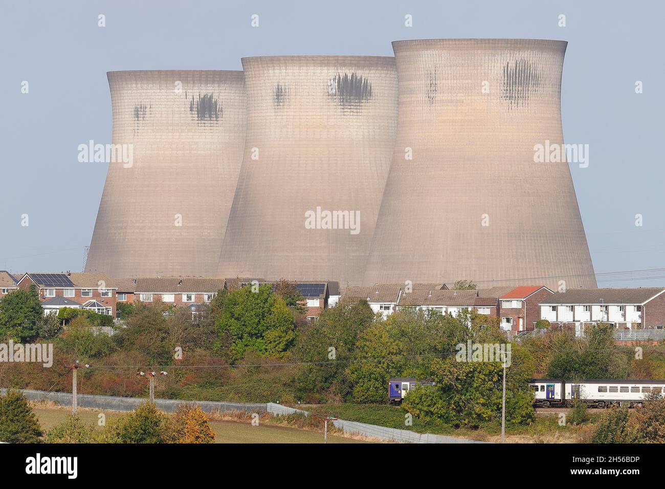 Un train Northern Rail passe devant Wentcliffe Estate et les 3 tours de refroidissement restantes de la centrale électrique de Ferrybridge dont la démolition est prévue Banque D'Images