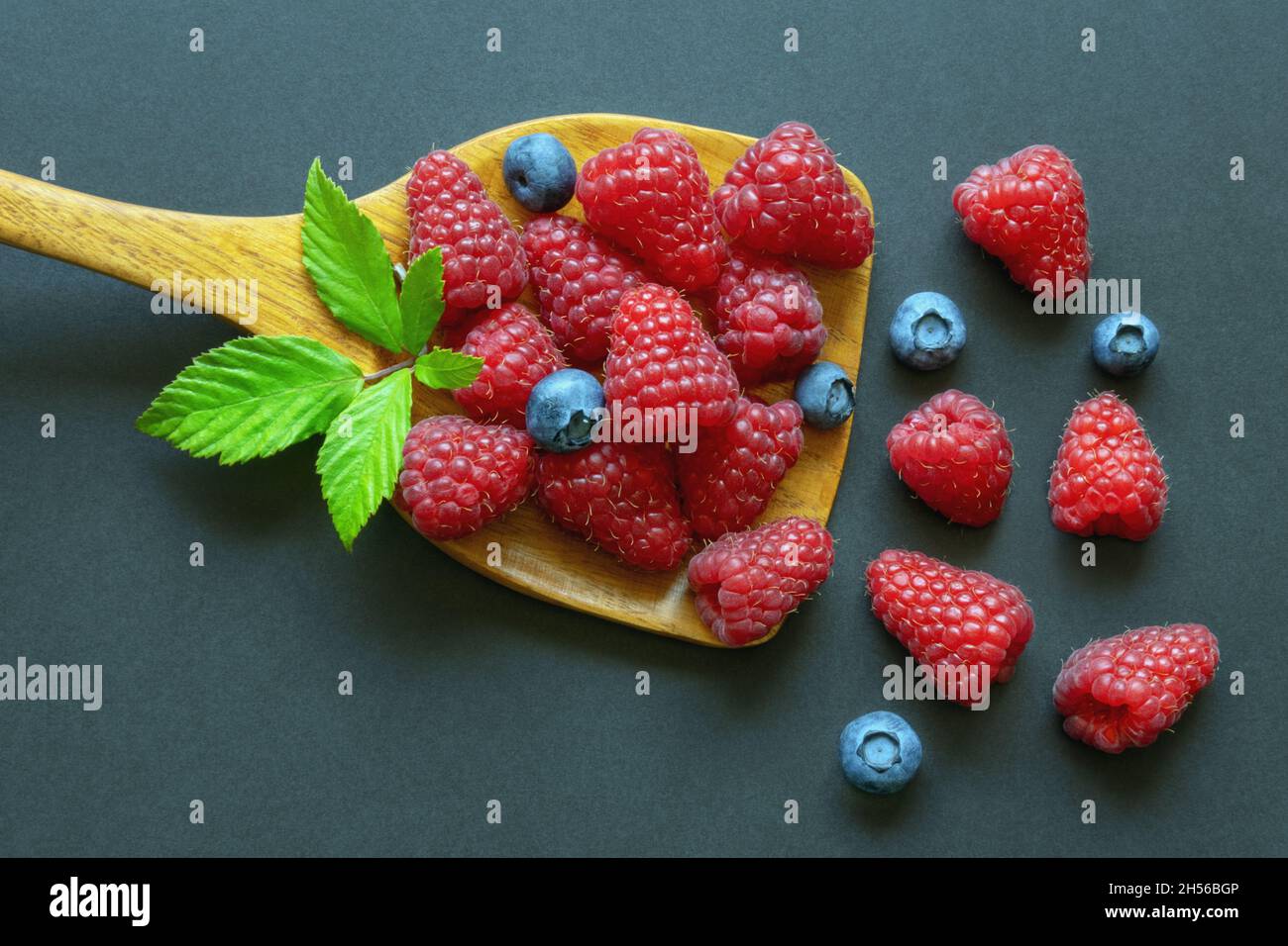 Baies fraîches mûres dans une cuillère en bois.Framboise et myrtille.Pose à plat, espace libre pour le texte Banque D'Images