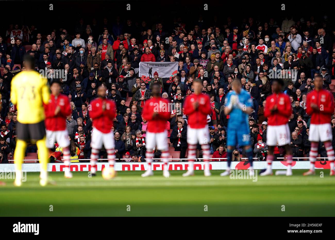 Les fans des stands tiennent une bannière Lest We Forget tandis que les joueurs se préparent à observer une minute de silence avant le jour du souvenir, avant le début du match de la Premier League au stade Emirates, Londres.Date de la photo: Dimanche 7 novembre 2021. Banque D'Images