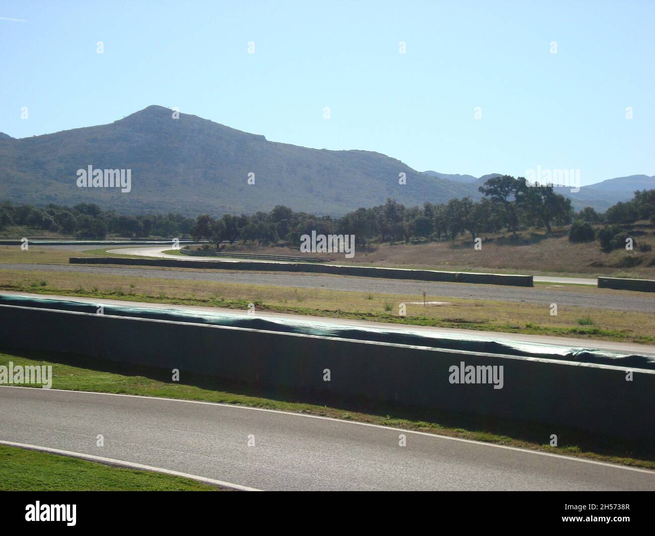 Ascari Race Resort : vue panoramique sur la piste, sans voiture par temps ensoleillé, avec montagnes en arrière-plan. Banque D'Images