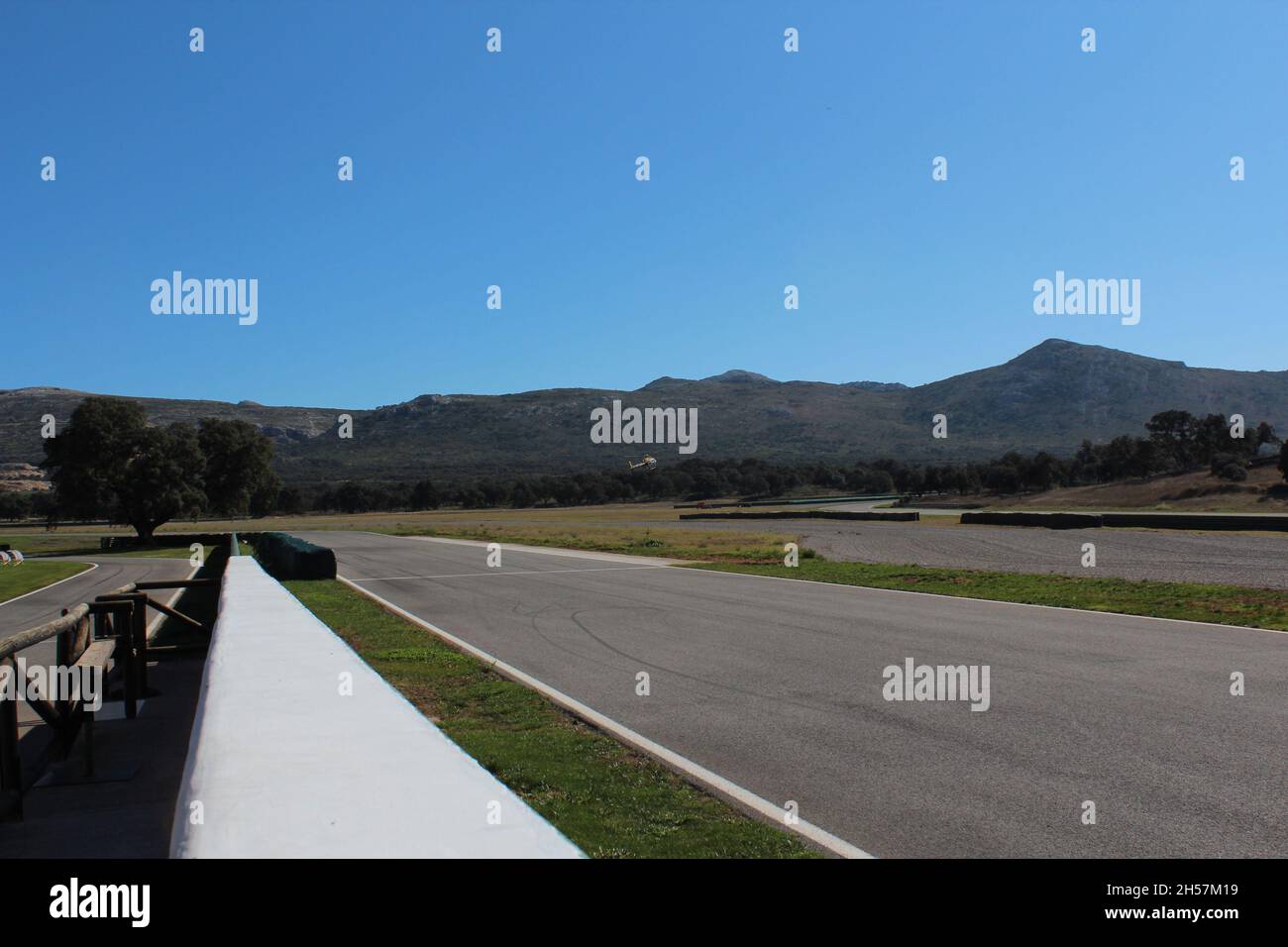 Ascari Race Resort : vue panoramique sur la piste, sans voiture par temps ensoleillé, avec montagnes en arrière-plan. Banque D'Images