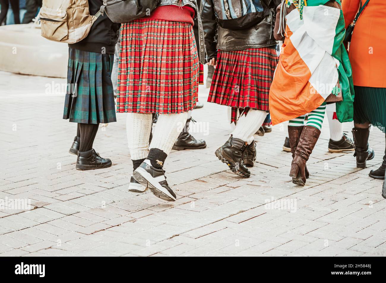 Jambes de jeunes, amis dans la rue de la ville, parade de jour de Saint Patrick, détails des costumes nationaux irlandais. Banque D'Images