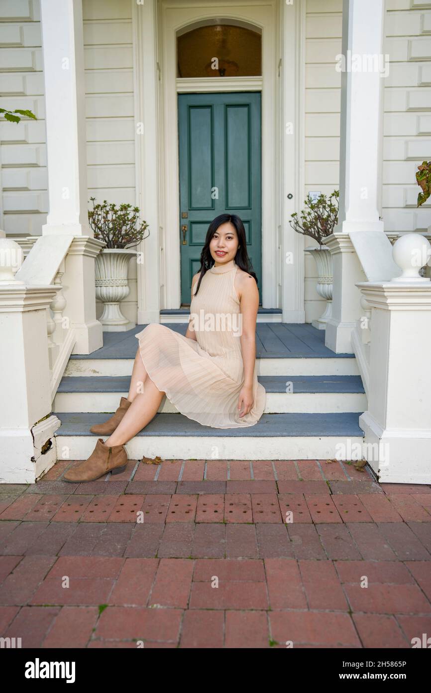 Jeune femme asiatique dans une maison victorienne historique et un jardin Banque D'Images