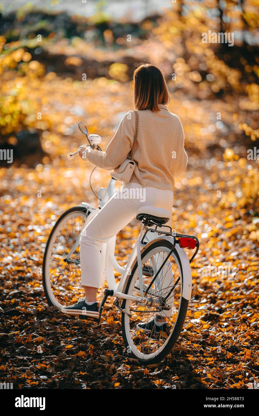Beau portrait de femme vélo seule dans le parc d'automne.Jour ensoleillé,  feuilles dorées en forêt.Femme tendance sur vélo blanc vintage, style de  vie sain Photo Stock - Alamy