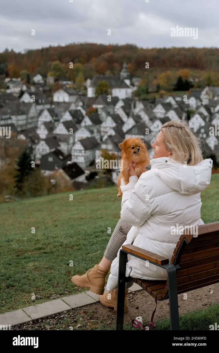 Jeune femme avec un joli pompon spitz dans la belle vieille ville allemande Freudenberg Banque D'Images