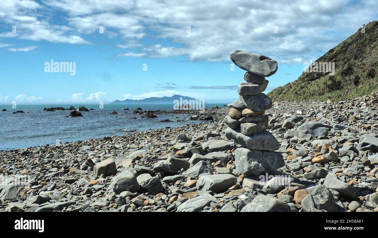 Une pile de pierres sur la piste de plage de la côte de Kapiti, entre la baie de Pukerua et Pimmersion.Île de Kapiti au large Banque D'Images