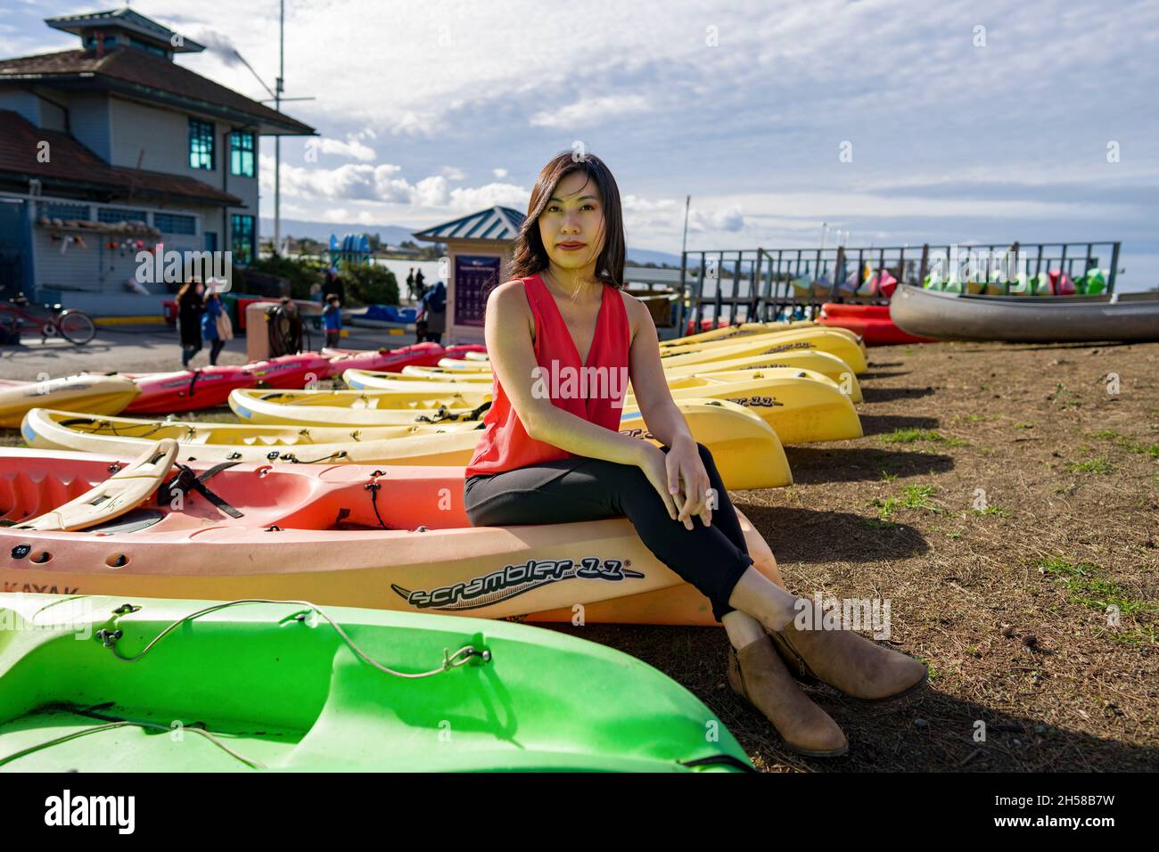 Jeune femme asiatique marchant autour d'un Boathouse à un lac Banque D'Images