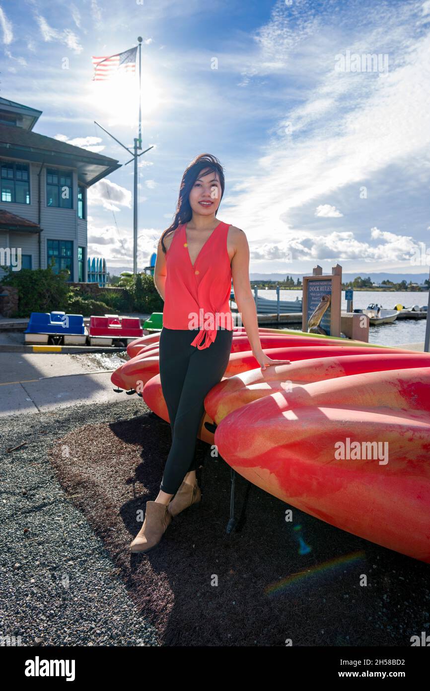 Jeune femme asiatique marchant autour d'un Boathouse à un lac Banque D'Images