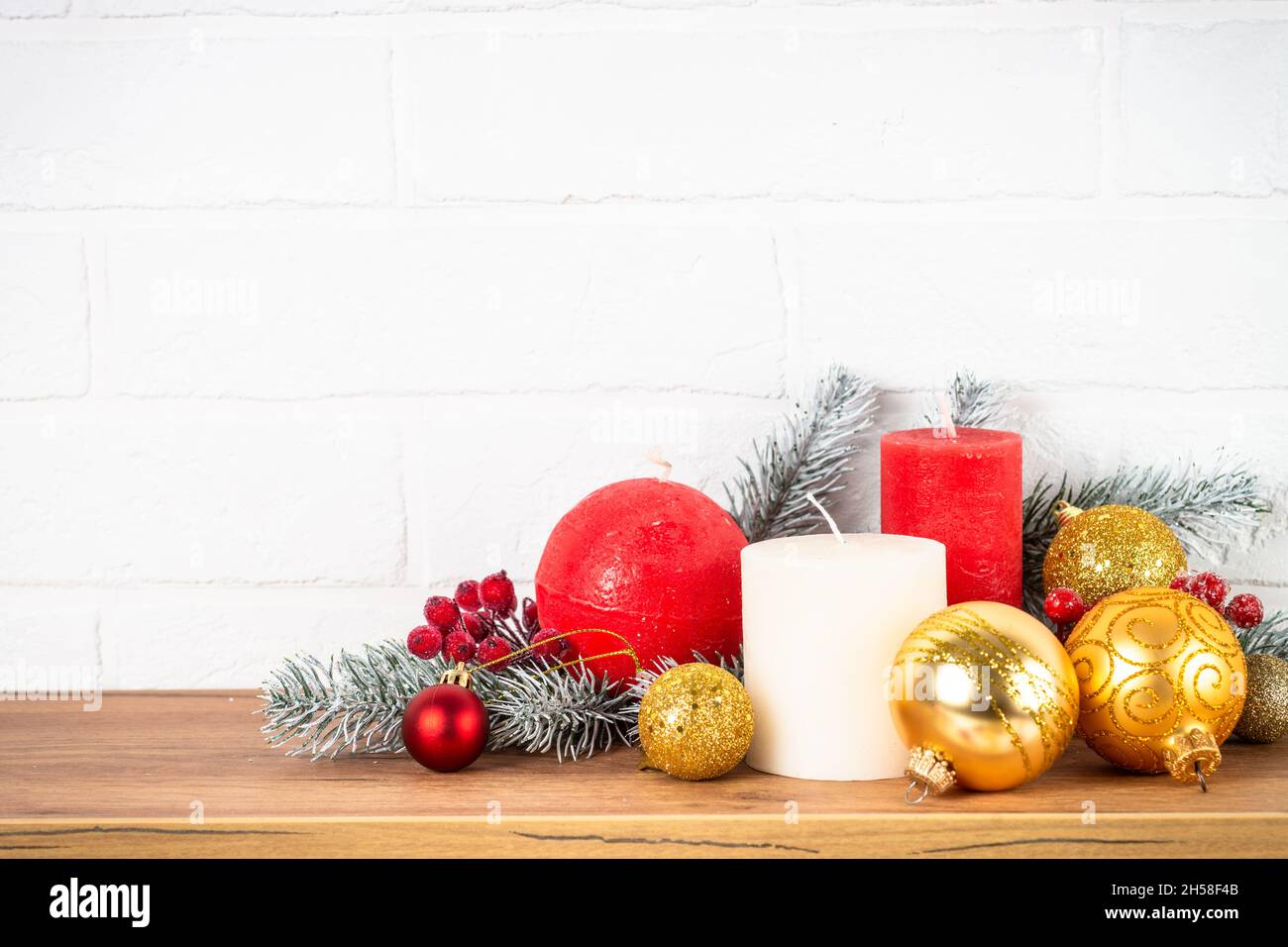 Décorations de Noël intérieur - étagère avec bougies, branches de sapin et décor doré. Banque D'Images