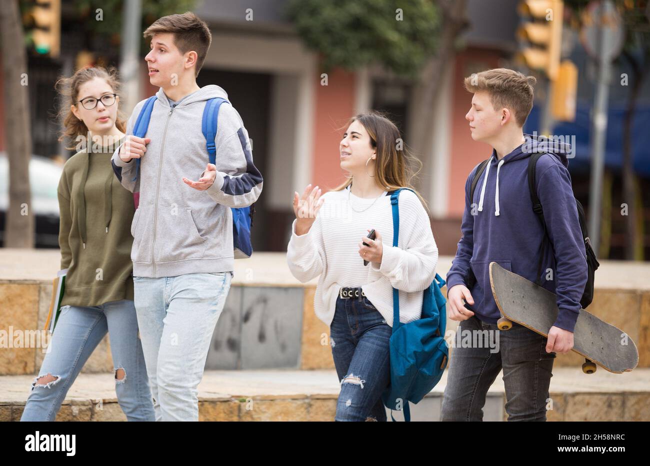 Des adolescents souriants qui marchent dehors après les leçons Banque D'Images