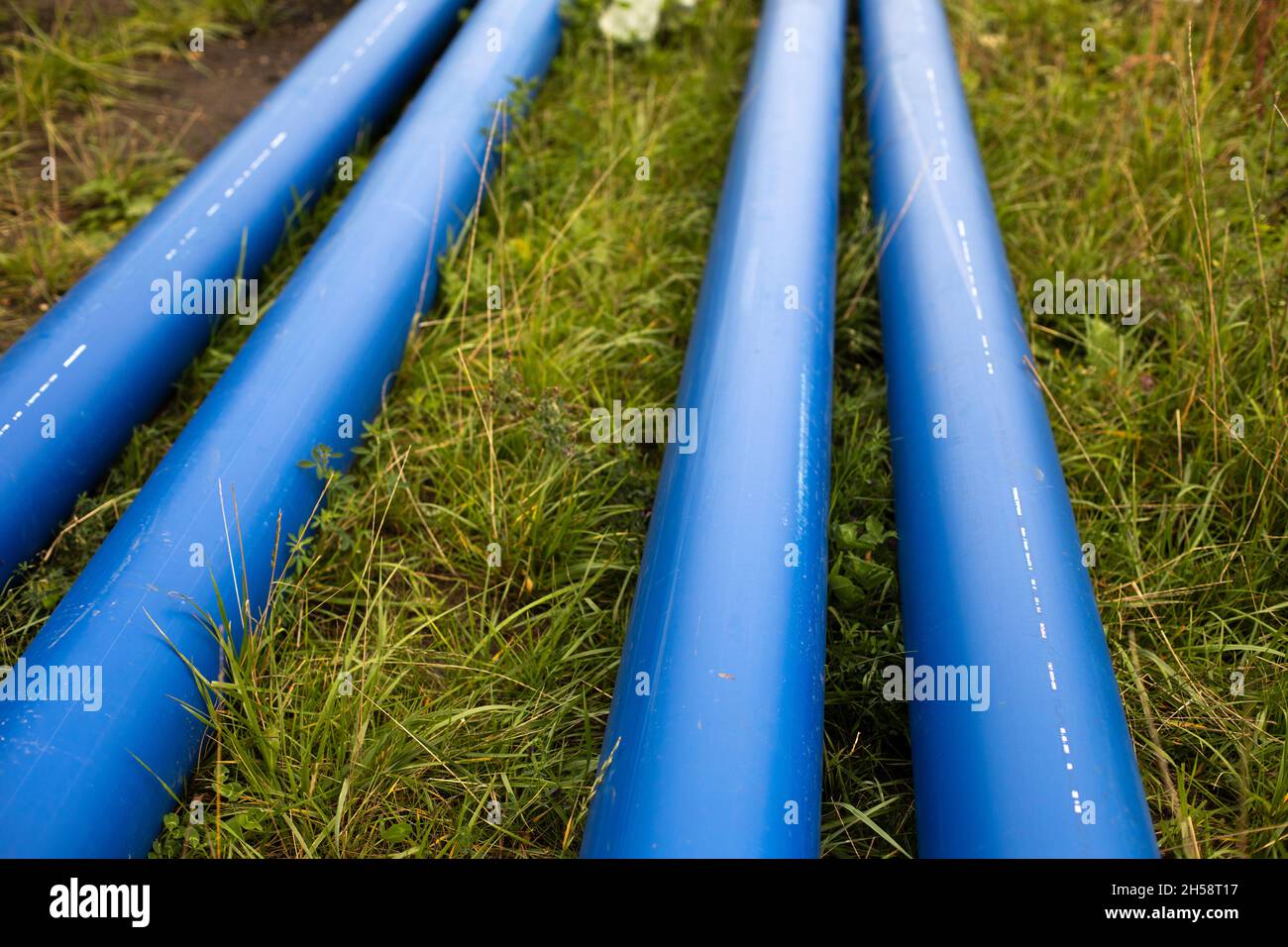 Tuyaux d'eau bleus.Les tuyaux industriels reposent sur le sol.Détails de pose de tuyaux avec gaz.Réparation des égouts. Banque D'Images