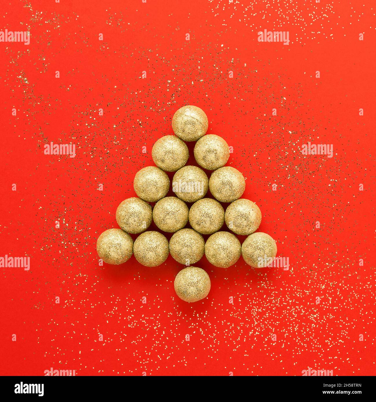 Carte de nouvel an et de Noël.Arbre de Noël en boules de Noël dorées sur fond rouge vif.Concept de Noël minimal.Pose à plat Banque D'Images Carte de nouvel an et de Noël.Arbre de Noël en boules de Noël dorées sur fond rouge vif.Concept de Noël minimal.Pose à plat Banque D'Images