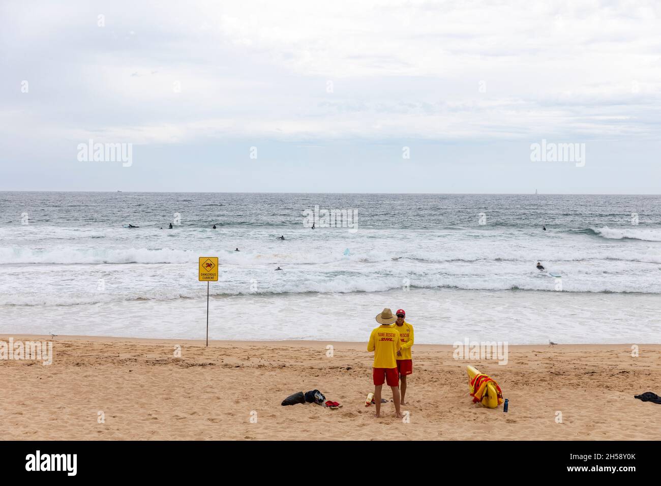 Surf sauvetage sauveteurs sur Manly Beach se tenait à côté d'un panneau de courant dangereux, Sydney, NSW, Australie Banque D'Images