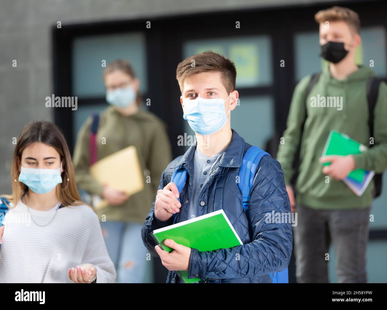 Adolescents dans les masques marchant après les leçons Banque D'Images