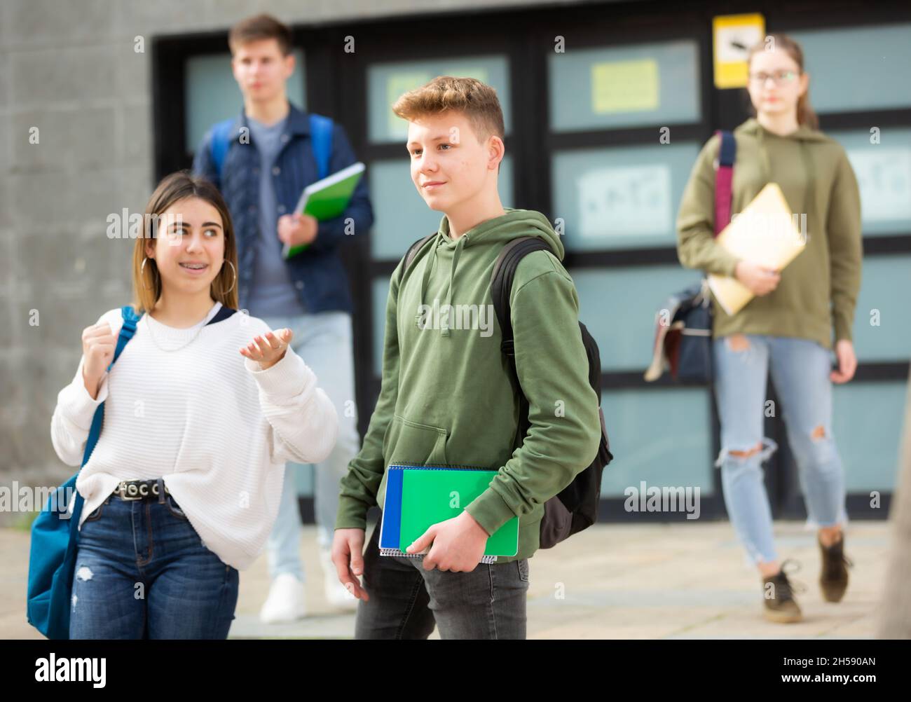 Des adolescents souriants qui marchent dehors après les leçons Banque D'Images