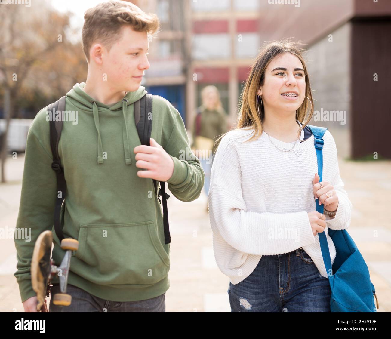 Des adolescents souriants qui marchent dehors après les leçons Banque D'Images