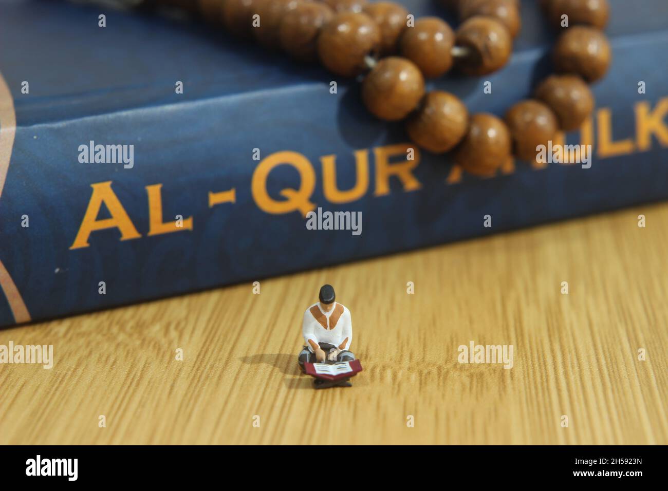 Simple Conceptual photo, Islam Homme ou musulman, Lire Al Quran, Al Qur'an près de la vraie perle de prière en bois Banque D'Images