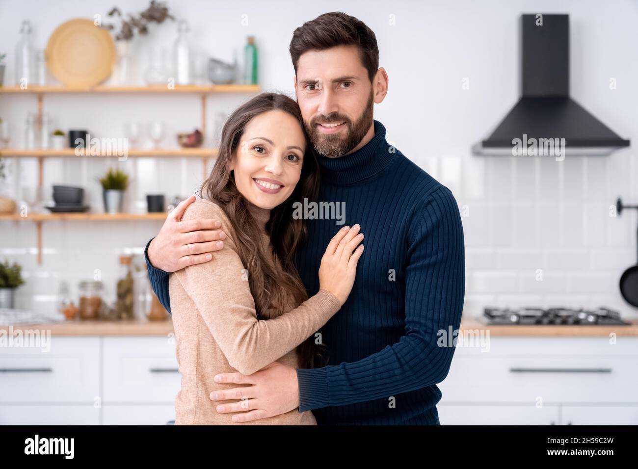 Épouse et mari amoureux se tenant à regarder l'appareil photo debout ensemble à la maison Banque D'Images