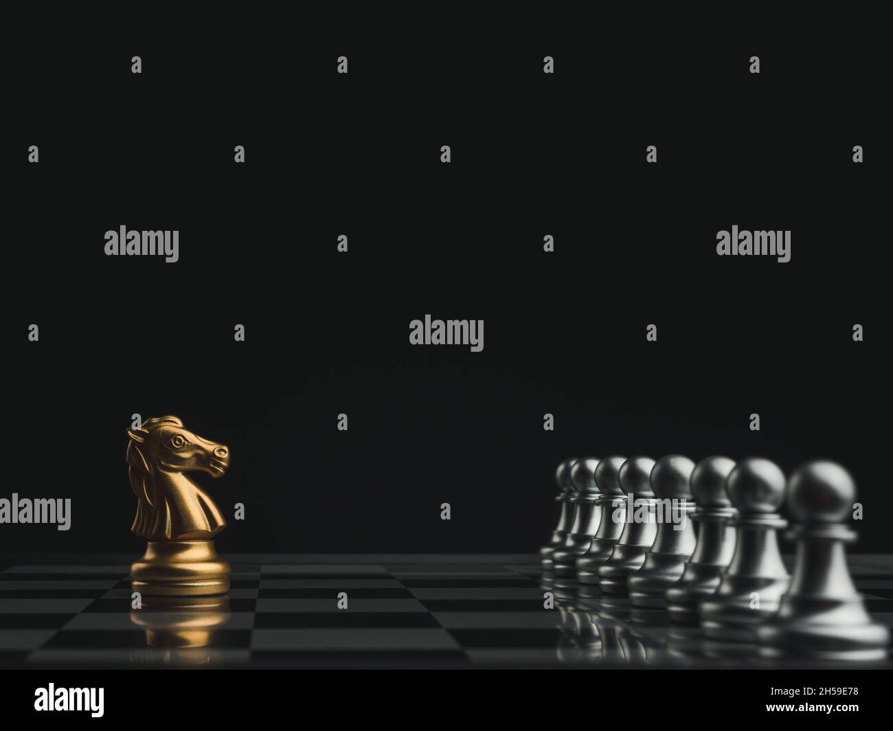 Le cheval d'or est une pièce d'échecs chevalier debout sur un échiquier avec des pièces d'échecs de pion d'argent sur un fond sombre.Leadership, influenceur, suiveur Banque D'Images