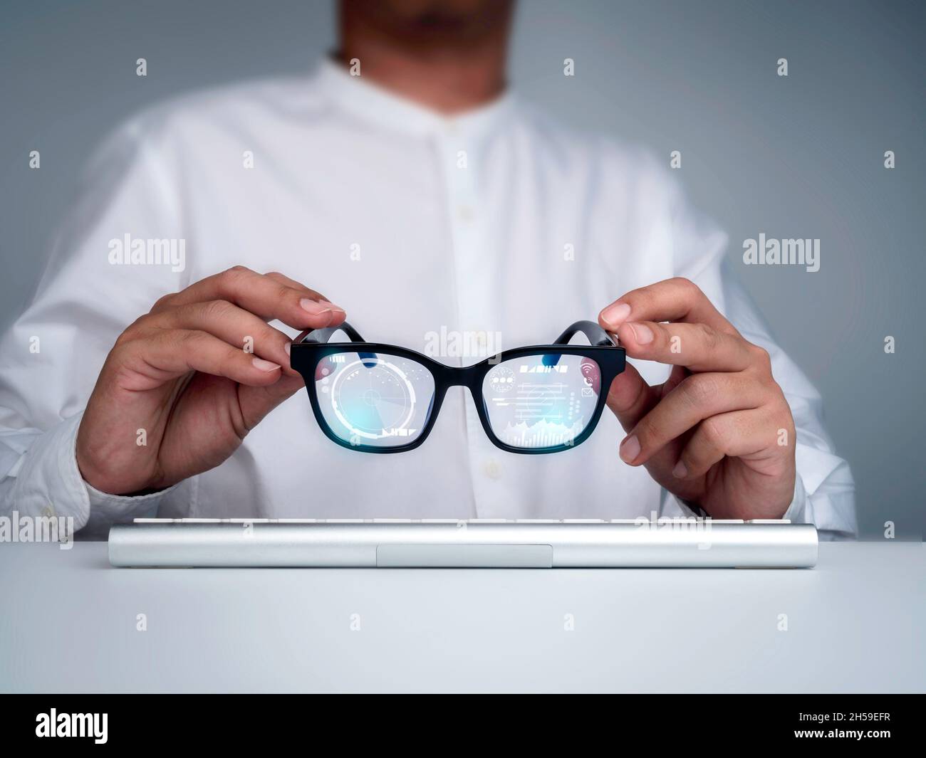 Lunettes intelligentes.Homme d'affaires en chemise blanche tenant des lunettes intelligentes avec des informations numériques sur l'écran virtuel interface haute technologie.Technologie futuriste Banque D'Images