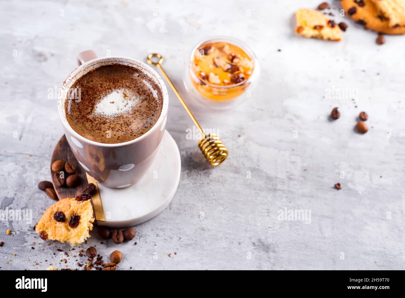 Tasse à café avec biscuits au chocolat sur fond de pierre avec miel et bâton de miel en métal avec espace de copie Banque D'Images