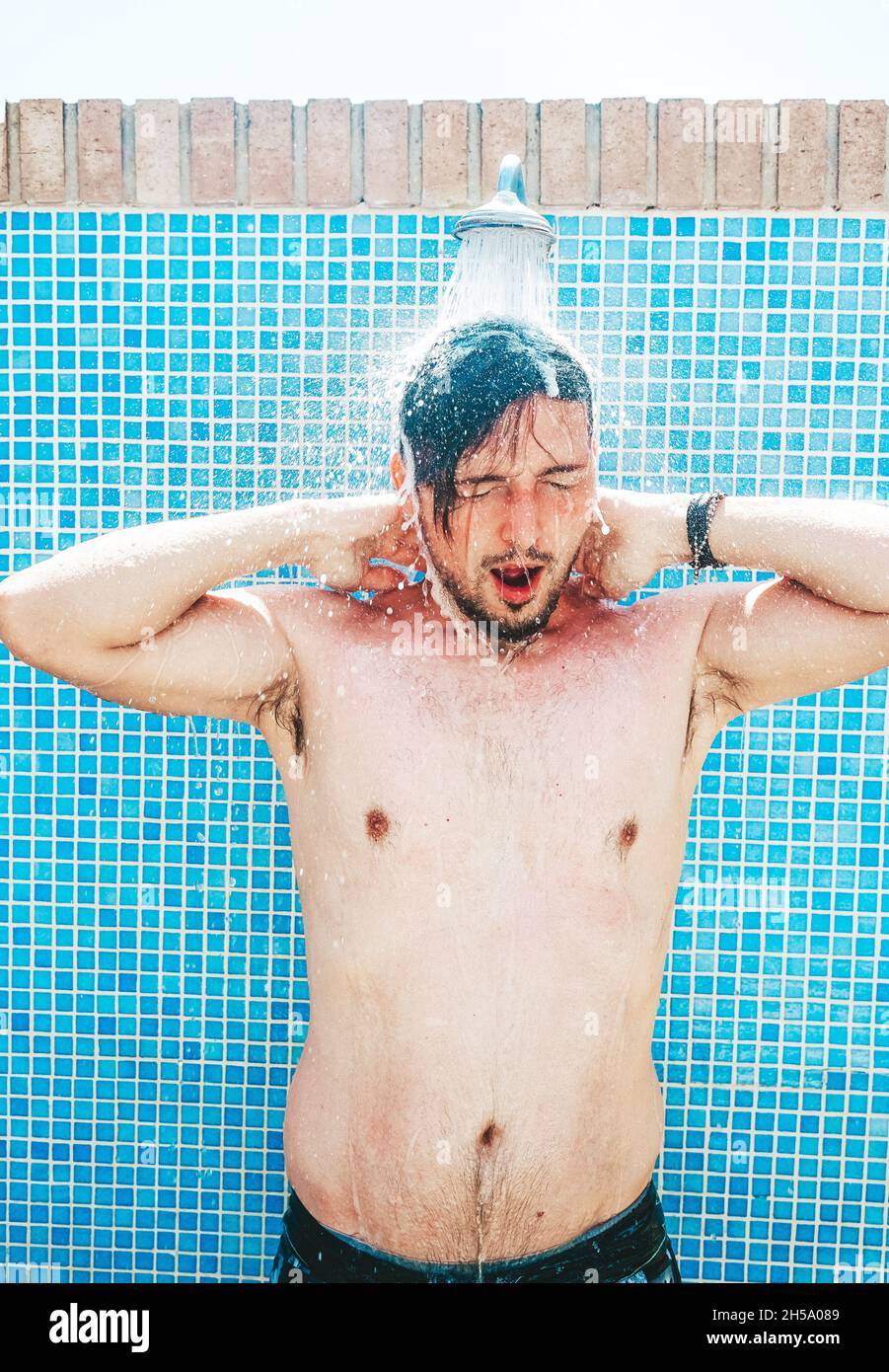 Jeune homme ayant une douche avant la piscine Photo Stock - Alamy