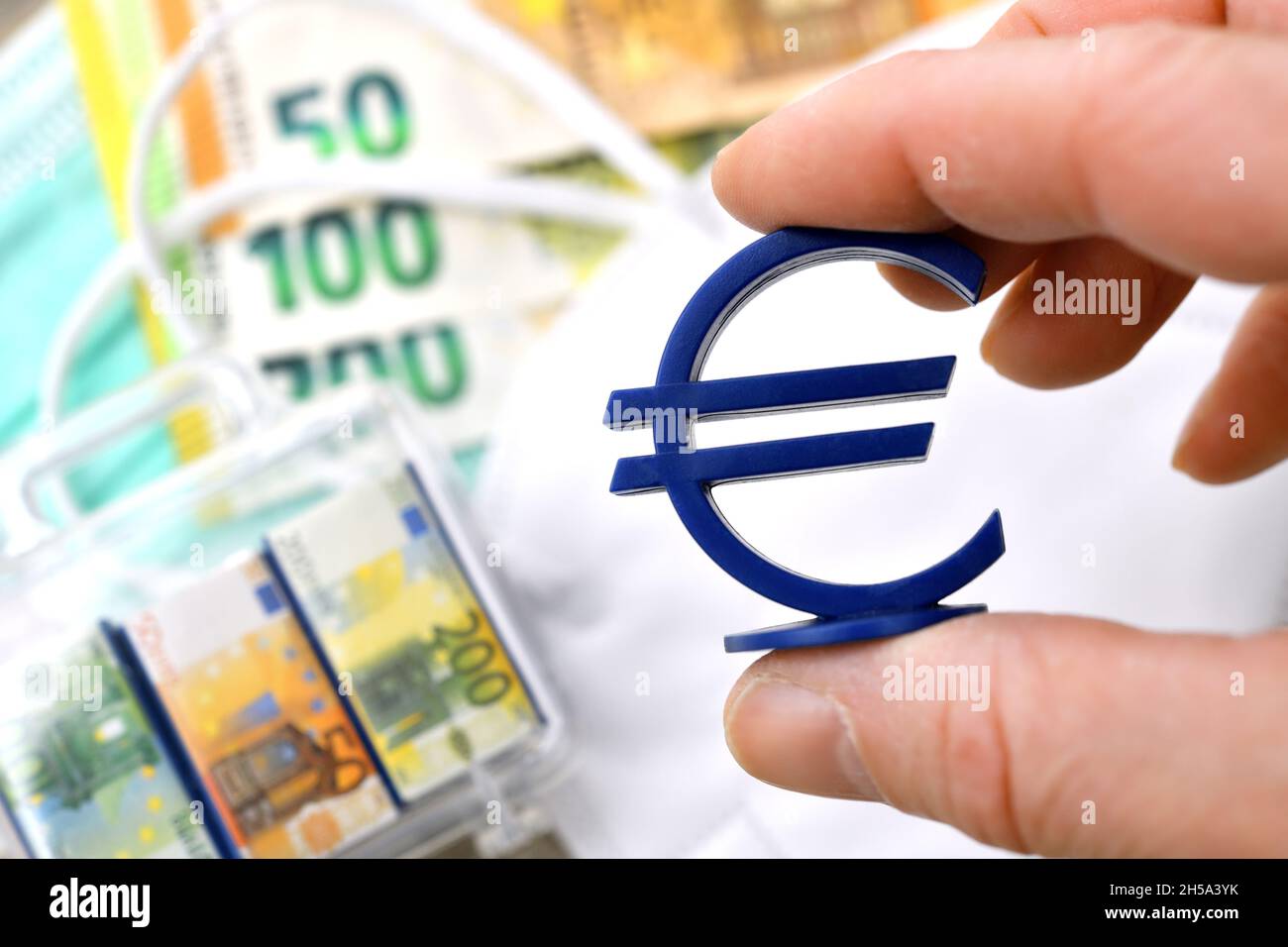 Hält Eurozeichen über Schutzmasken und Geldscheinen, Symbolfoto Maskenaffäre Banque D'Images