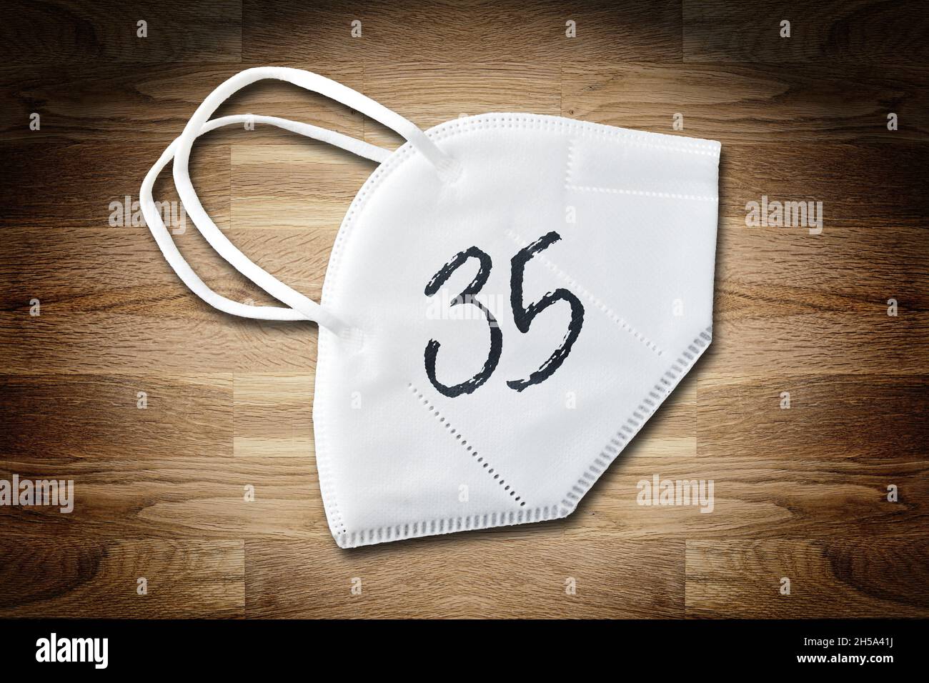FOTOMONTAGE, FFP2-Schutzmaske auf einem Tisch mit der Aufschrift 35, Symbolfoto Inzidenzwert Banque D'Images