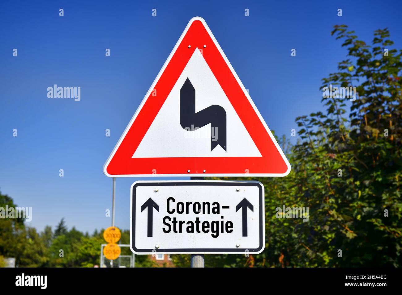 FOTOMONTAGE, Schild mit KurvenSymbol und Aufschrift Corona-Strategie, Symbolfoto fuer Schlingerkurs in der Corona-Pandemiebekaempfung Banque D'Images