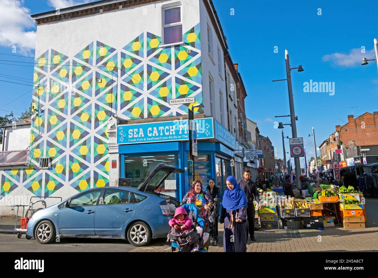 Des femmes musulmanes magasinent dans Walthamstow High Street en marchant dans la rue des légumes de fruits stalle à l'automne soleil octobre 2021 Londres UK KATHY DEWITT Banque D'Images