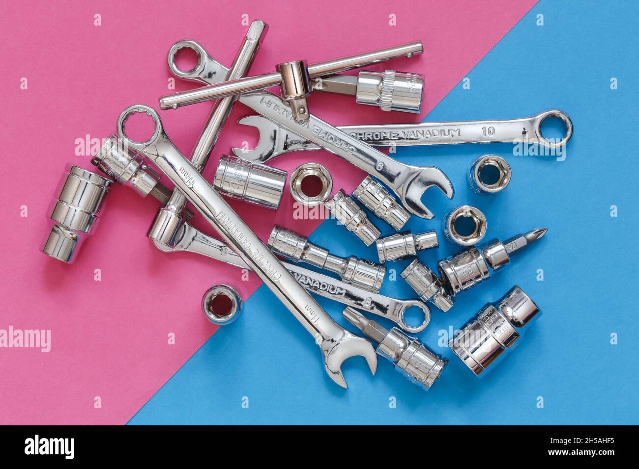 Diverses clés et outils sur fond diagonal rose et bleu, vue de dessus Banque D'Images