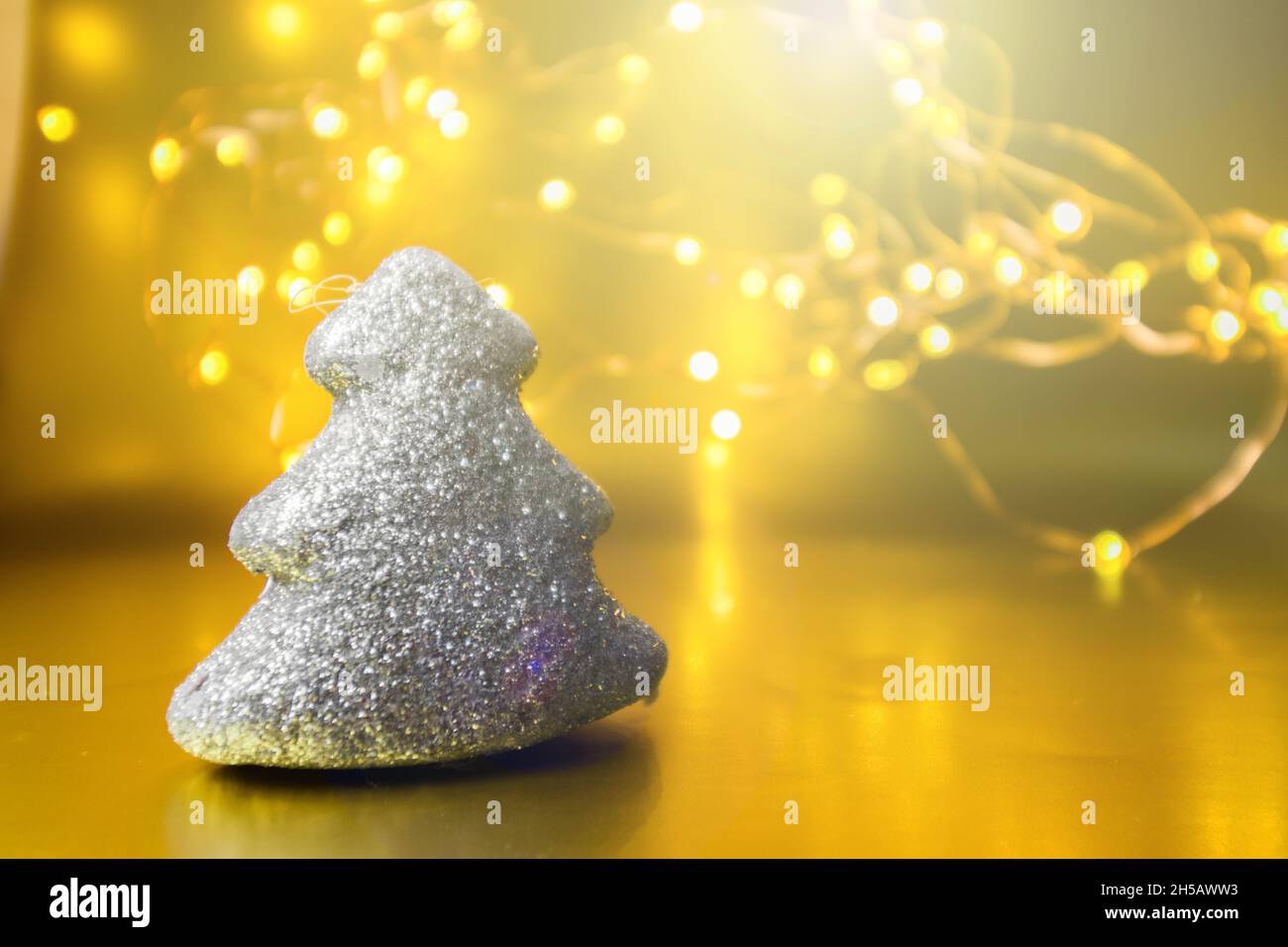 Noël jouet arbre brillant sur un fond doré avec des lumières. Banque D'Images