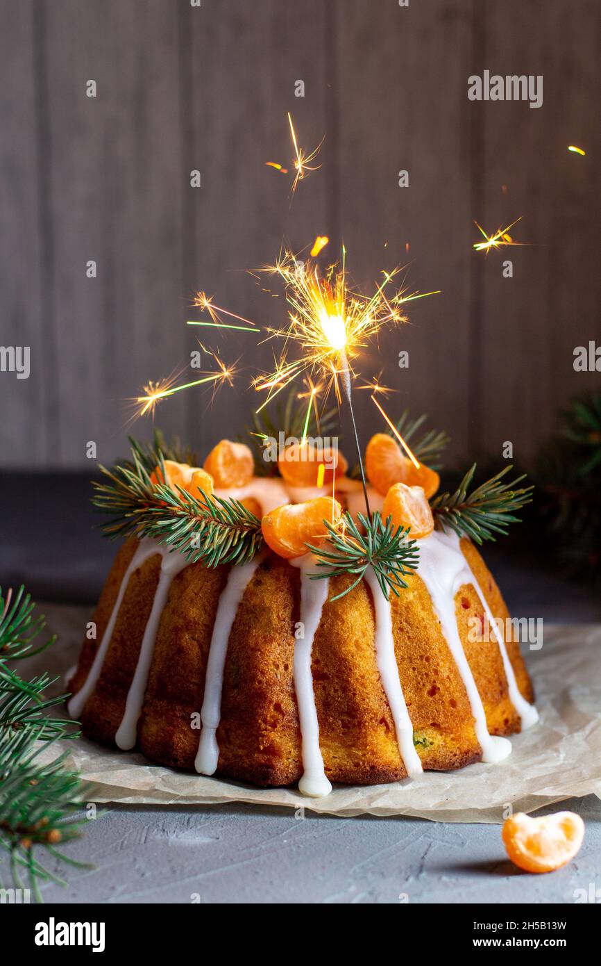 Gâteau de Noël aux fruits confits décoré de tranches de mandarine givrantes et de branches de sapin avec des biscuits.Noël fêtes concept de fête du nouvel an Banque D'Images