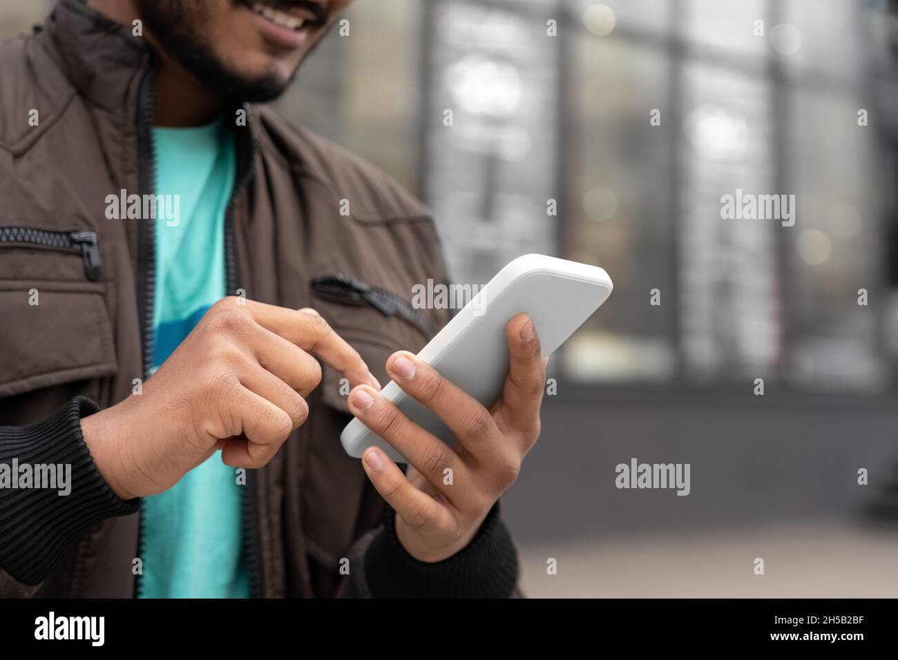 Gros plan d'un Indien tenant un téléphone portable avec message texte debout à l'extérieur Banque D'Images