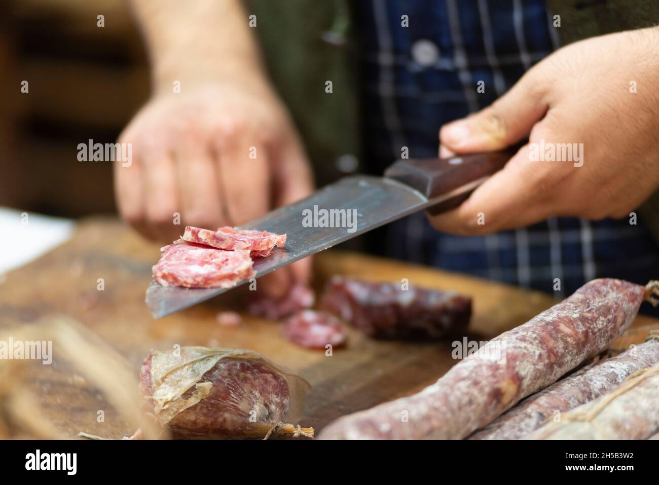 Italie, Emilia Romagna, Piacenza, salami avec couteau en acier qui coupe Banque D'Images