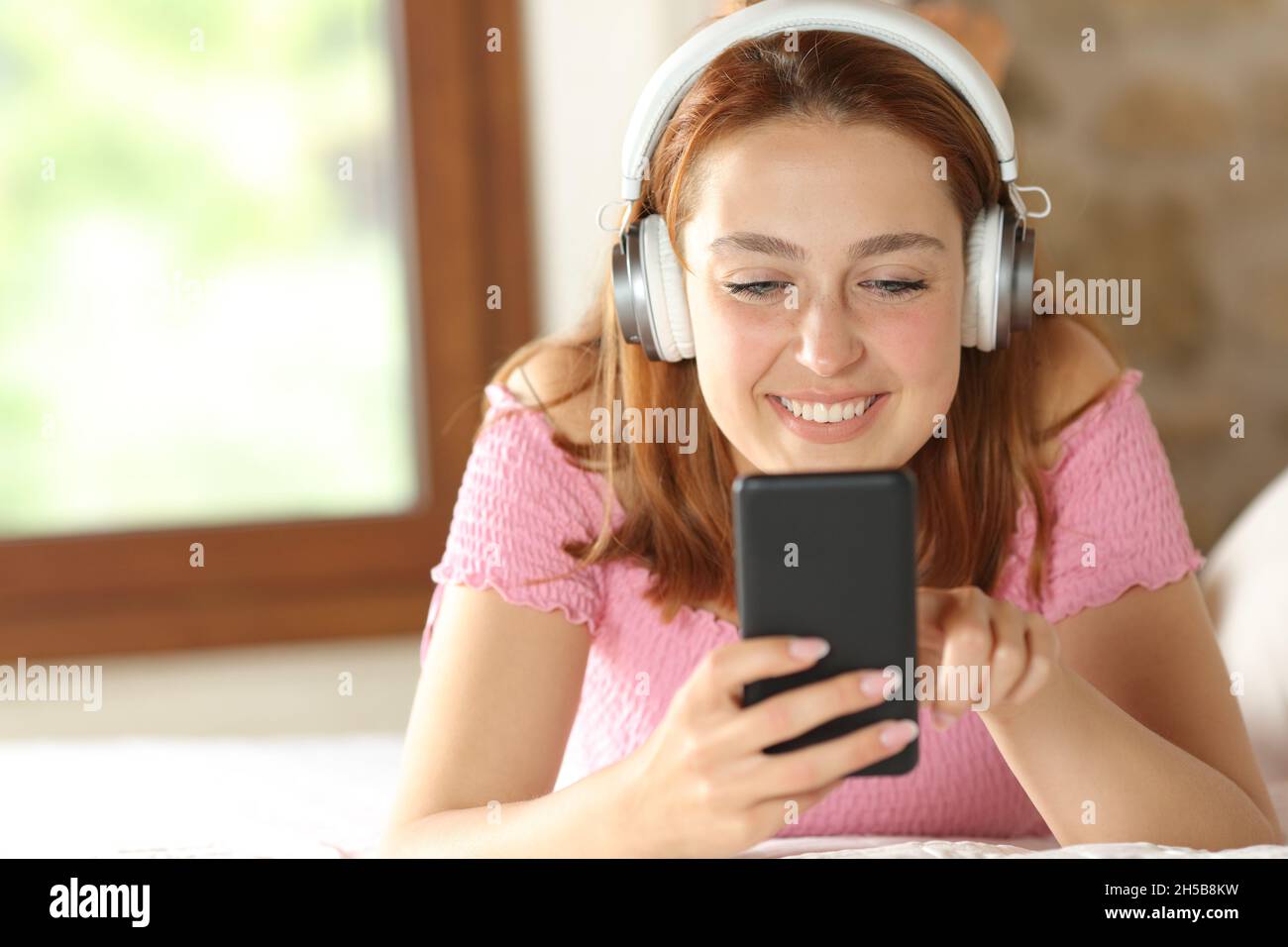 Vue avant portrait d'une femme heureuse écoutant de la musique sur la perle à la maison Banque D'Images