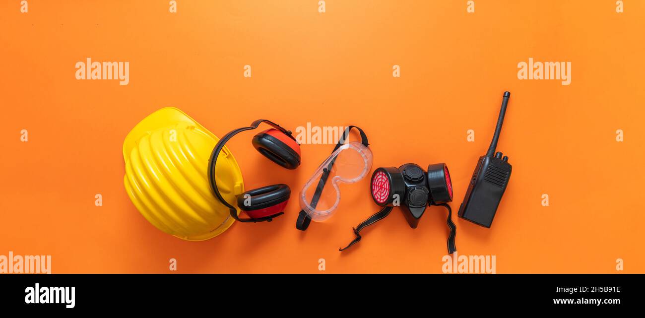 Concept de santé et de sécurité des travailleurs du chantier de construction industrielle.Travailler porter un équipement de protection sur fond orange, équipement de protection individuelle, à Banque D'Images Concept de santé et de sécurité des travailleurs du chantier de construction industrielle.Travailler porter un équipement de protection sur fond orange, équipement de protection individuelle, à Banque D'Images