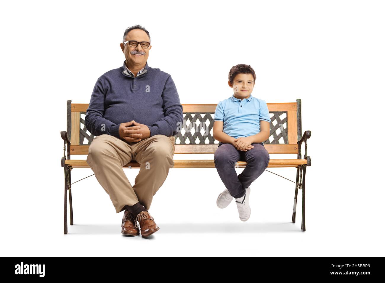 Homme mature et garçon assis sur un banc et regardant la caméra isolée sur fond blanc Banque D'Images