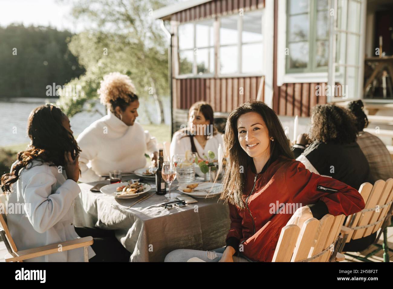 Portrait d'une femme avec des amies mangeant pendant la fête le jour ensoleillé Banque D'Images