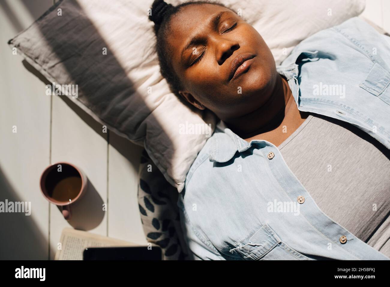 Directement au-dessus de la vue de la femme couché avec les yeux fermés au soleil Banque D'Images