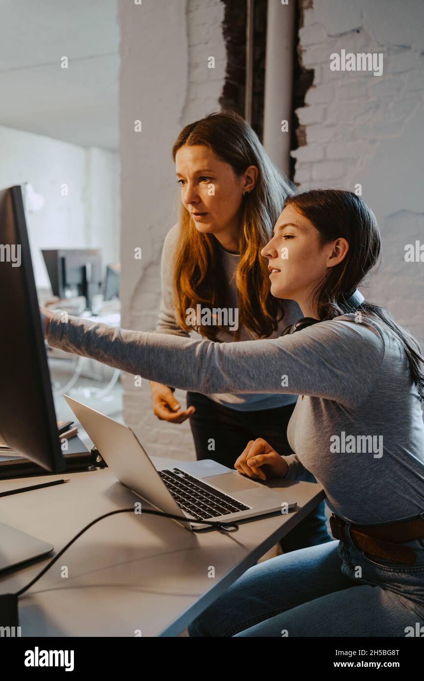 Des hackers féminins communiquent lorsqu'ils travaillent sur un ordinateur au bureau Banque D'Images