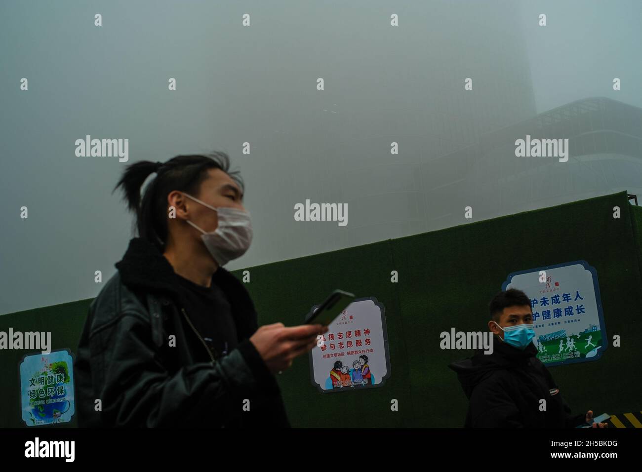 Les gens portent des masques pour se protéger à la fois contre le covid-19 et le smog lourd à Beijing, en Chine.06 novembre 2021 Banque D'Images