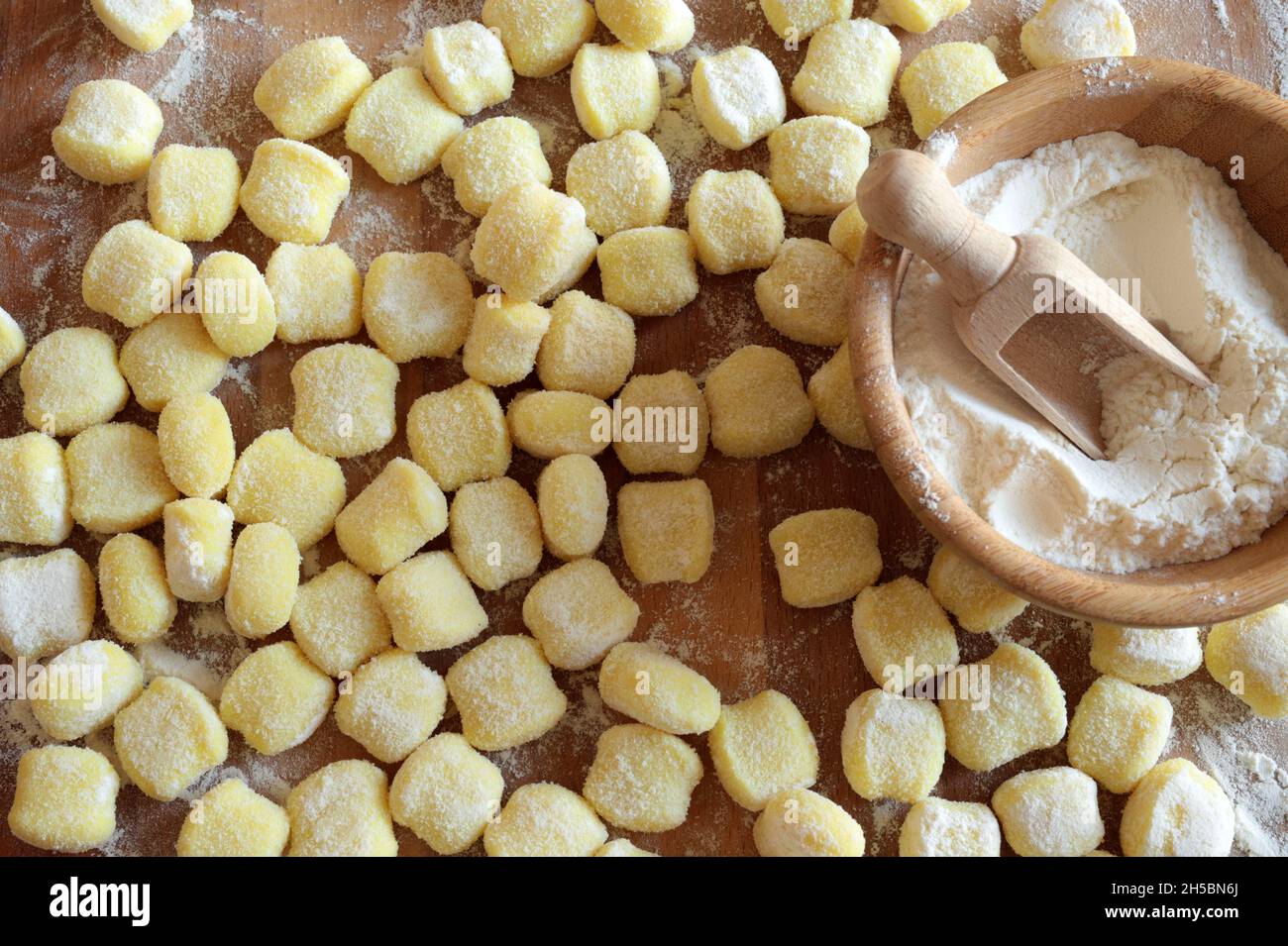 Gnocchi de pomme de terre cru non cuit, isolé sur une table en bois.Directement au-dessus.Cuisine maison. Banque D'Images
